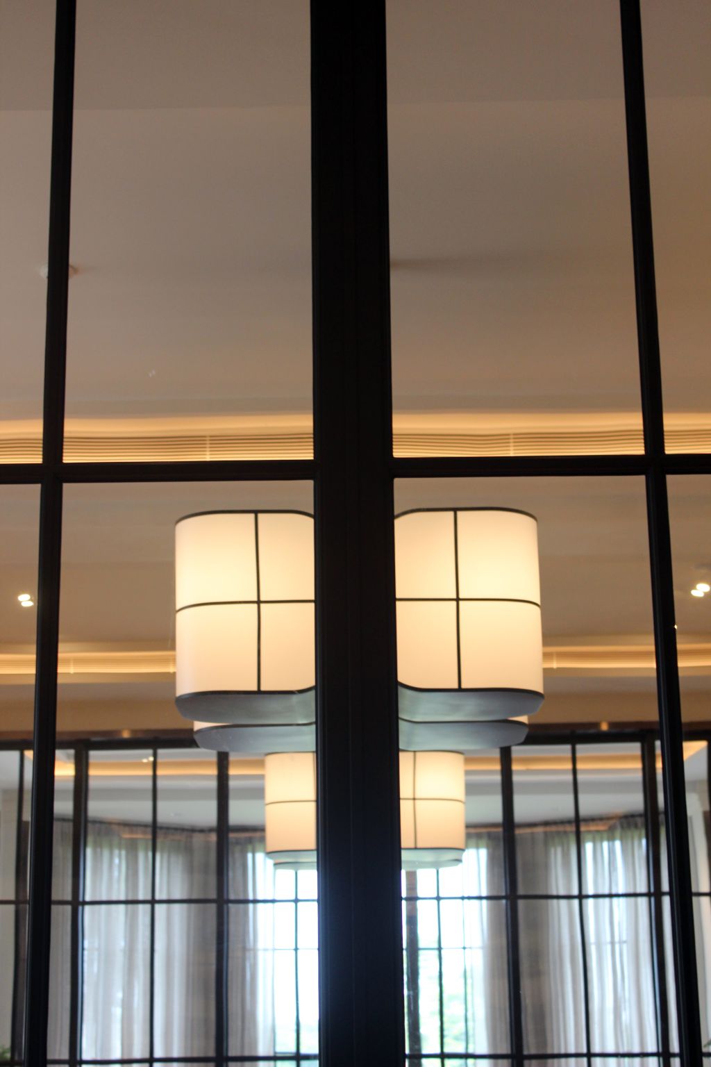 Amsterdam pendant lights seen through the interior's black-framed glazing
