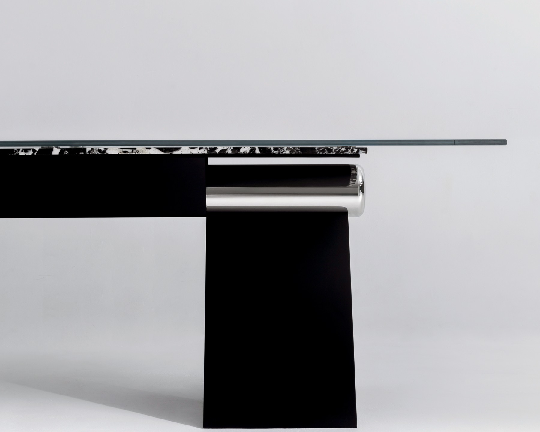 Side profile of the HINGE table showing its glass edge, exposed joint and folded steel support